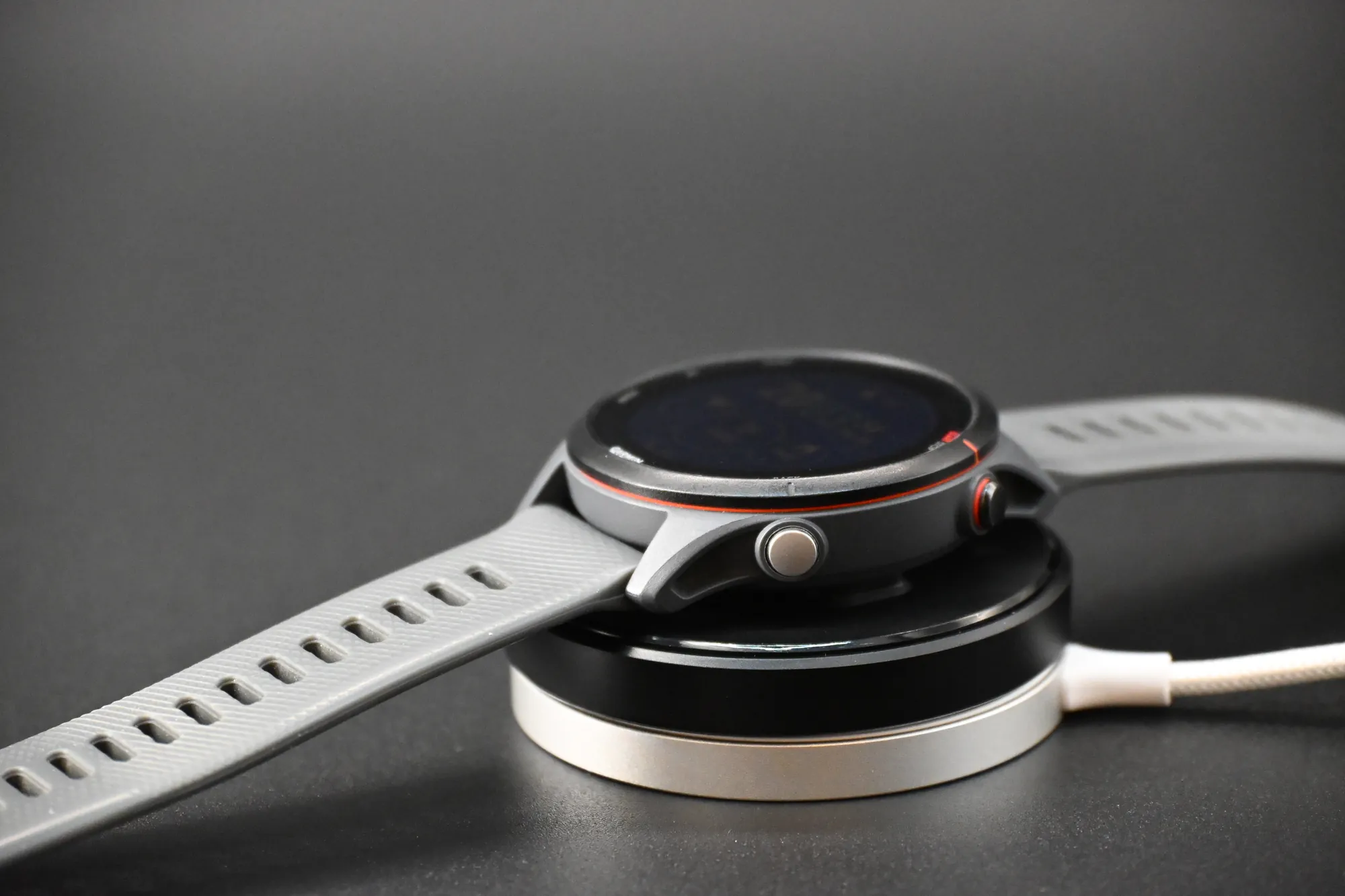 Garmin watch charging on the NEOKWIIX adapter on a magnetic wireless charger
